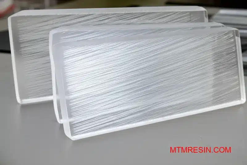 Close-up of glass-reinforced polymer parts showing fiber alignment patterns in composite material applications