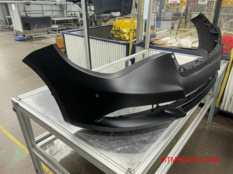 Black thermoplastic polyolefin automotive bumper fascia displaying superior impact resistance and paintable surface finish characteristics similar to Daplen EE188HP grade material