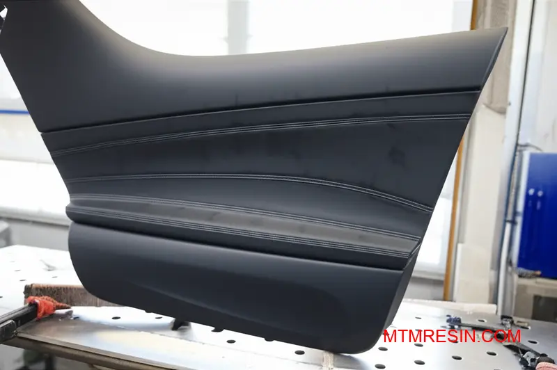 Close-up of surface imperfections on a high-impact polyolefin component with visible flow marks.