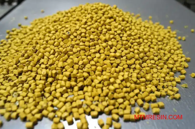 A close-up of yellowish, impure acrylic styrene acrylonitrile pellets, representing counterfeit thermoplastic resin.