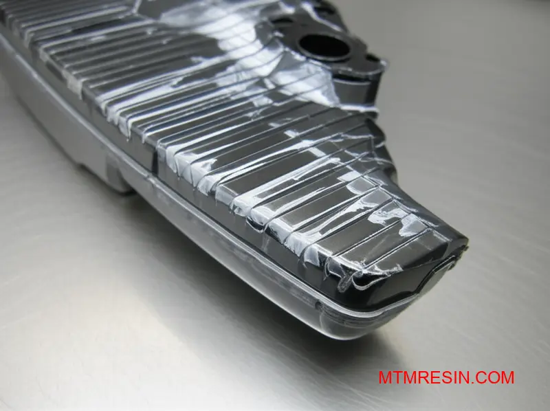 Zbliżenie szarej części z polimeru PC/ASA pokazujące srebrne smugi i wady rozwarstwienia.