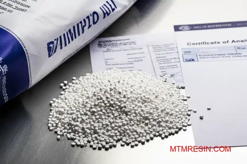 Gros plan sur des granulés blancs d'acrylonitrile butadiène styrène authentiques à côté de leur certificat d'analyse.