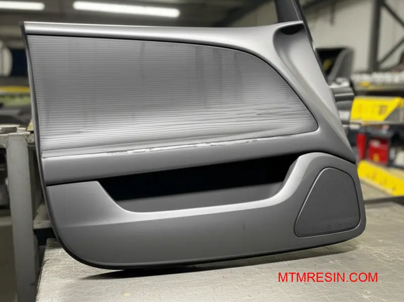 Et nærbillede af flydemærker og tigerstribefejl på en mørkegrå plastkomponent til biler.