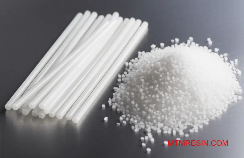 Makrobild av långa glasfiberpolypropylenpellets och kortfibergranulat på en arbetsbänk.